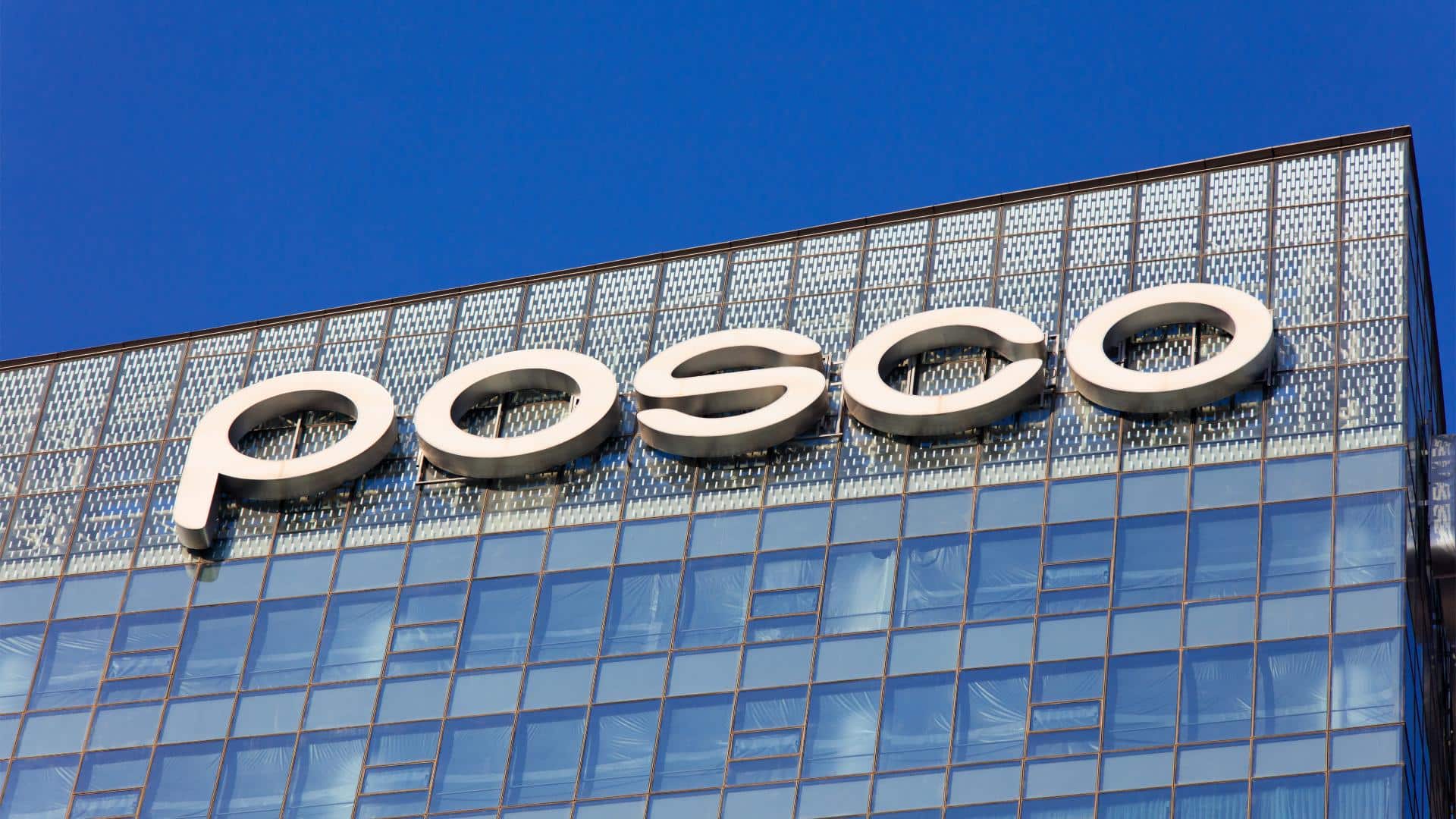 POSCO lettering on a glass-fronted building under a blue sky